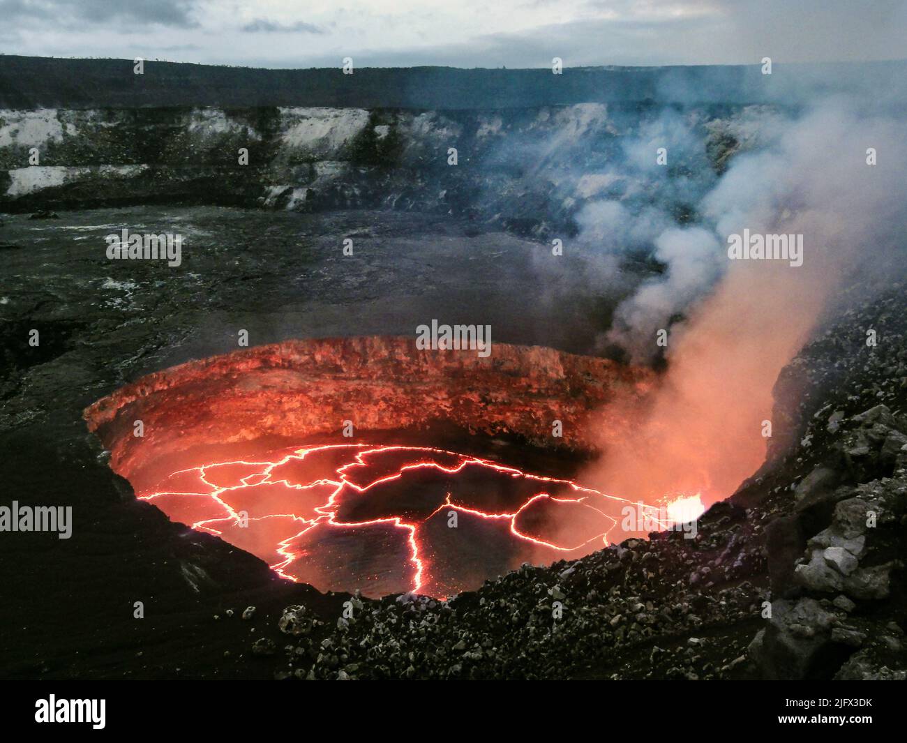 Kilauea Lava Lake, Hawaii, USA. Il lago di lava è contenuto all'interno di un cratere chiamato informalmente il cratere 'Overlook' (a causa della sua posizione immediatamente sotto l'ex vista dei visitatori di Halema?uma?u), e questo cratere si trova all'interno del più grande cratere Halema?uma?u. La foto è stata scattata dal bordo del cratere Halema?uma?u. Il lago di lava si trova a circa 50 m (160 piedi) sotto il bordo del cratere di osservazione. Il livello è sceso leggermente il giorno precedente, lasciando un impiallacciatura nera di lava sulle pareti del cratere appena sopra il margine attuale e facilmente visibile in questa foto. Credito: USGS Foto Stock