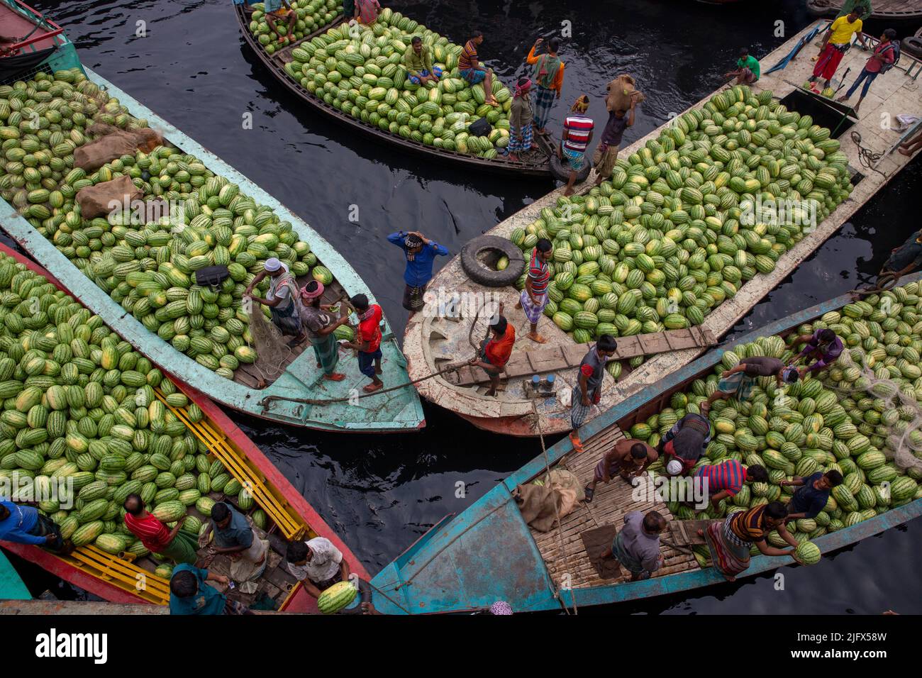 Barche di pranzo con i cocomeri ancorato Dhaka Badamtali del mercato della frutta terminale, più tardi rispetto al solito, aumentando le forniture. Dacca in Bangladesh Foto Stock