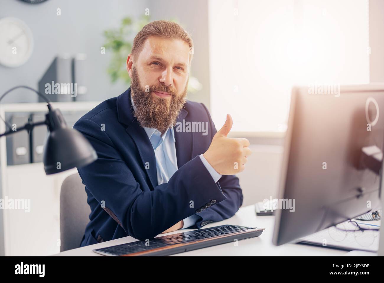 Uomo d'affari che gesturing pollice in su Foto Stock