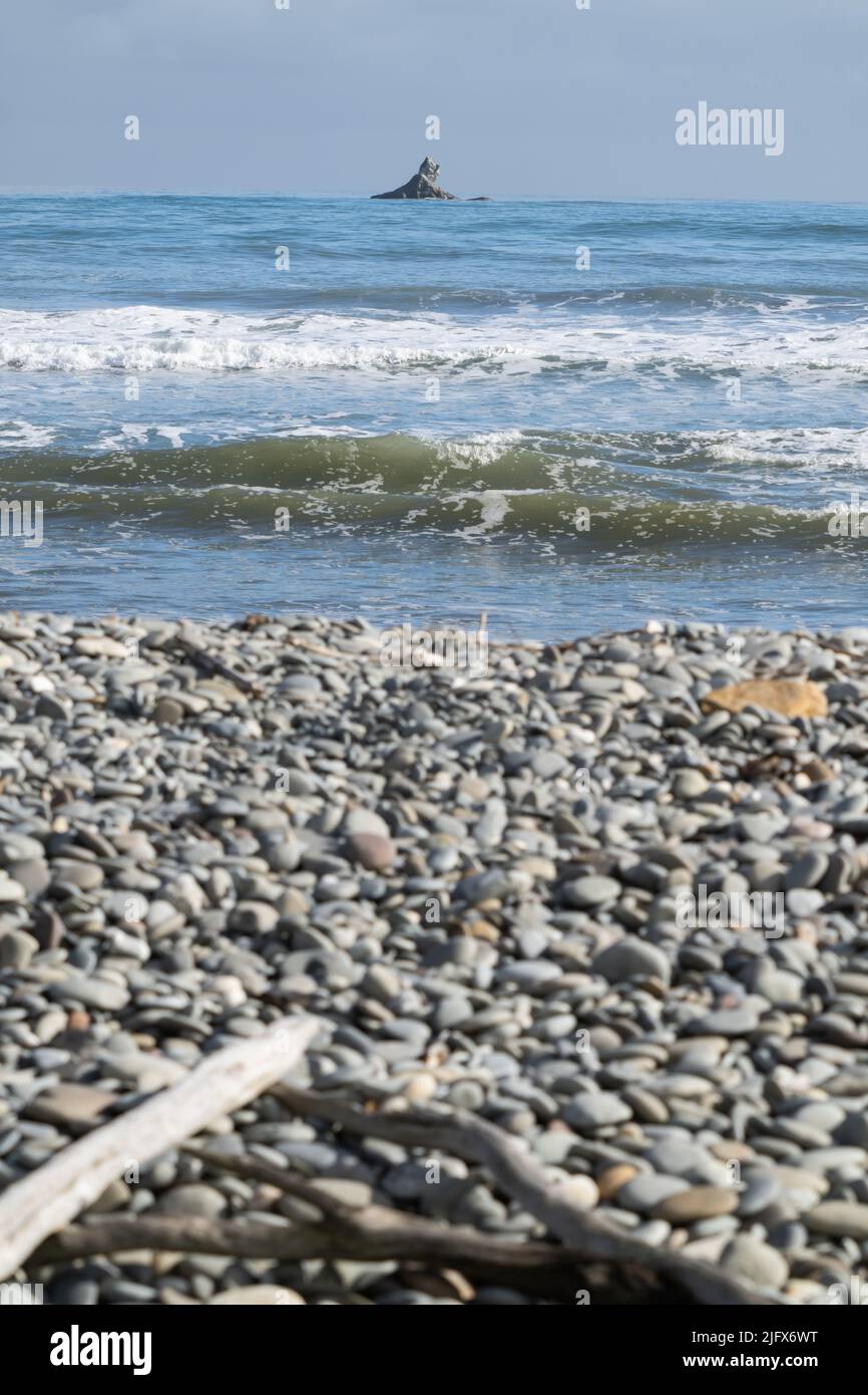 Roccia off-shore oltre la spiaggia di pietra Rapahoe e vista all'orizzonte con promontorio e onde di surf, Reefton, South Island New Z1ealand. Foto Stock