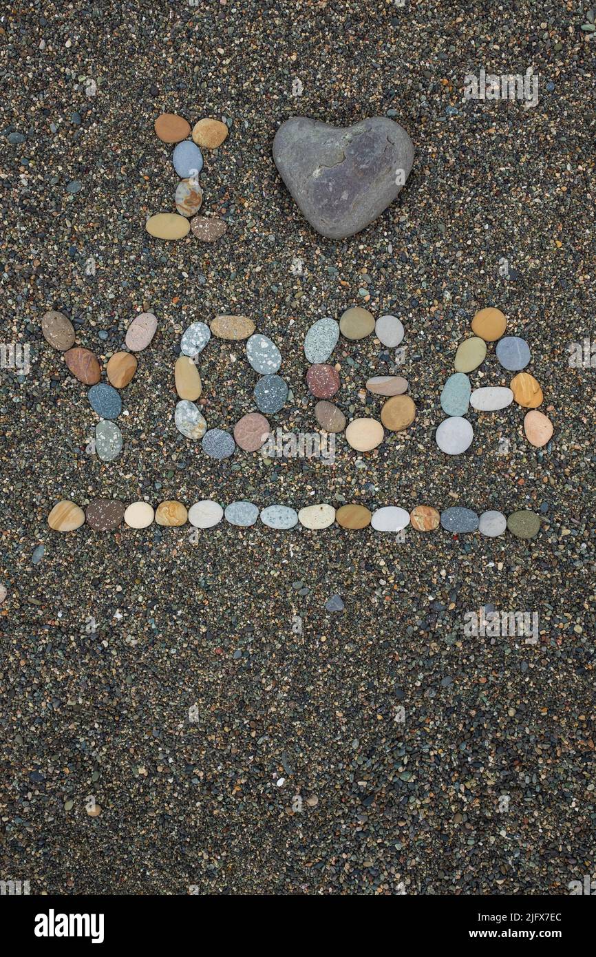 I Love Yoga testo fatto da pietre sulla spiaggia. Vista dall'alto Foto Stock