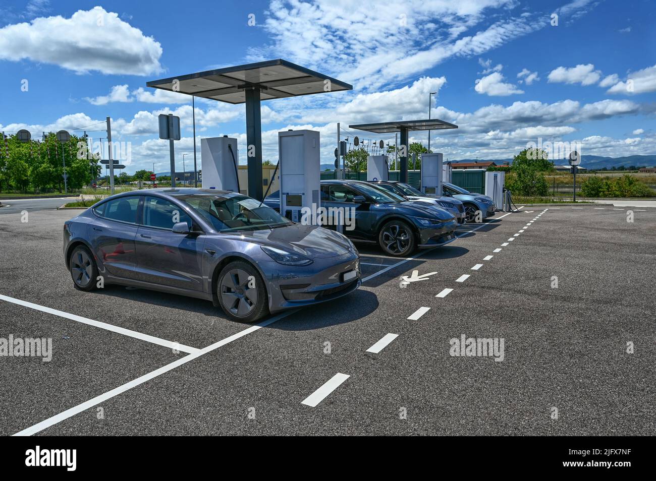 Francia, autostrada per Parigi, giugno 2022. In una zona di sosta autostradale, un gruppo di auto elettriche si sta rifornendo di energia elettrica presso la stazione di ricarica rapida. Foto Stock