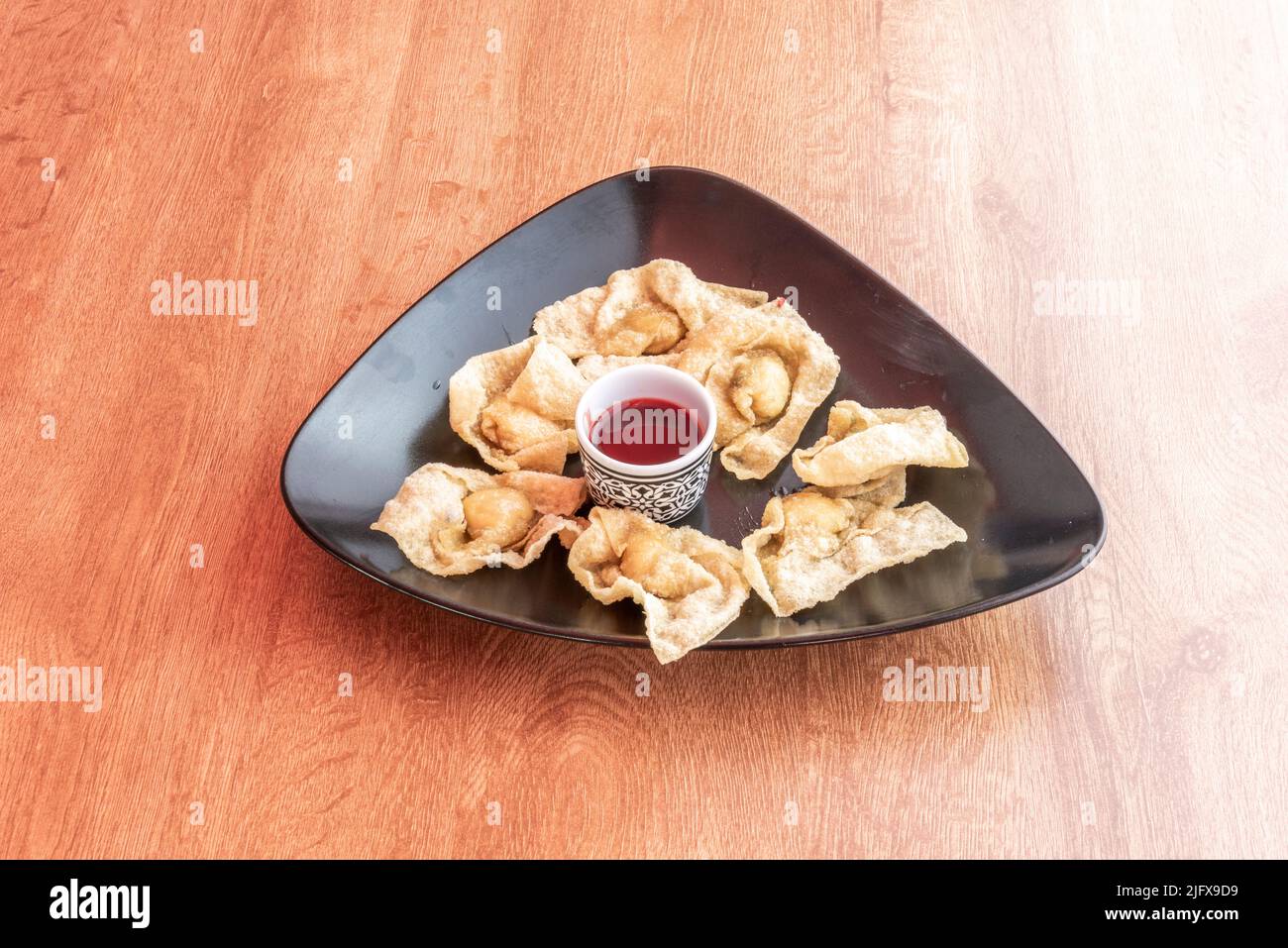 Won ton è un impasto molto sottile e farcito molto comune nella cucina cinese. Si consuma cotto in zuppe e fritto come antipasto o parte del piatto Foto Stock