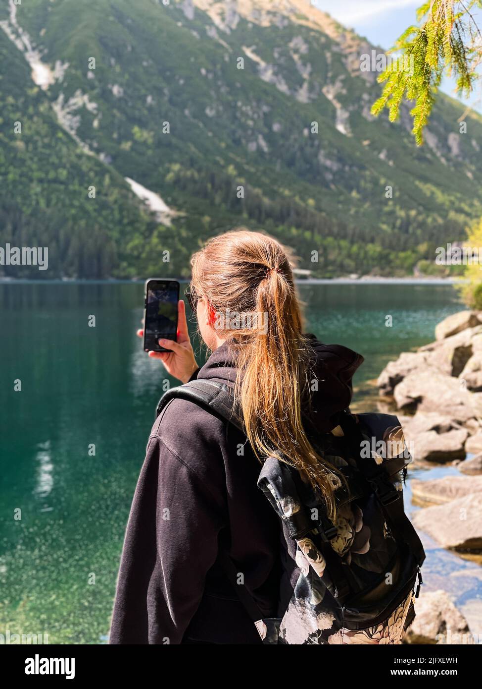 Giovane donna che scatta foto del lago di montagna Morskie oko a Tatra Foto Stock