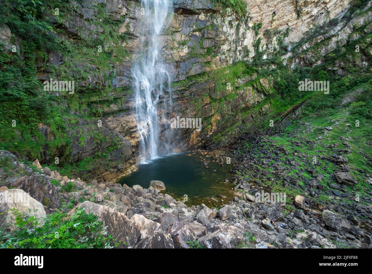 Splendida vista su una grande cascata verde selvaggia e pareti rocciose Foto Stock