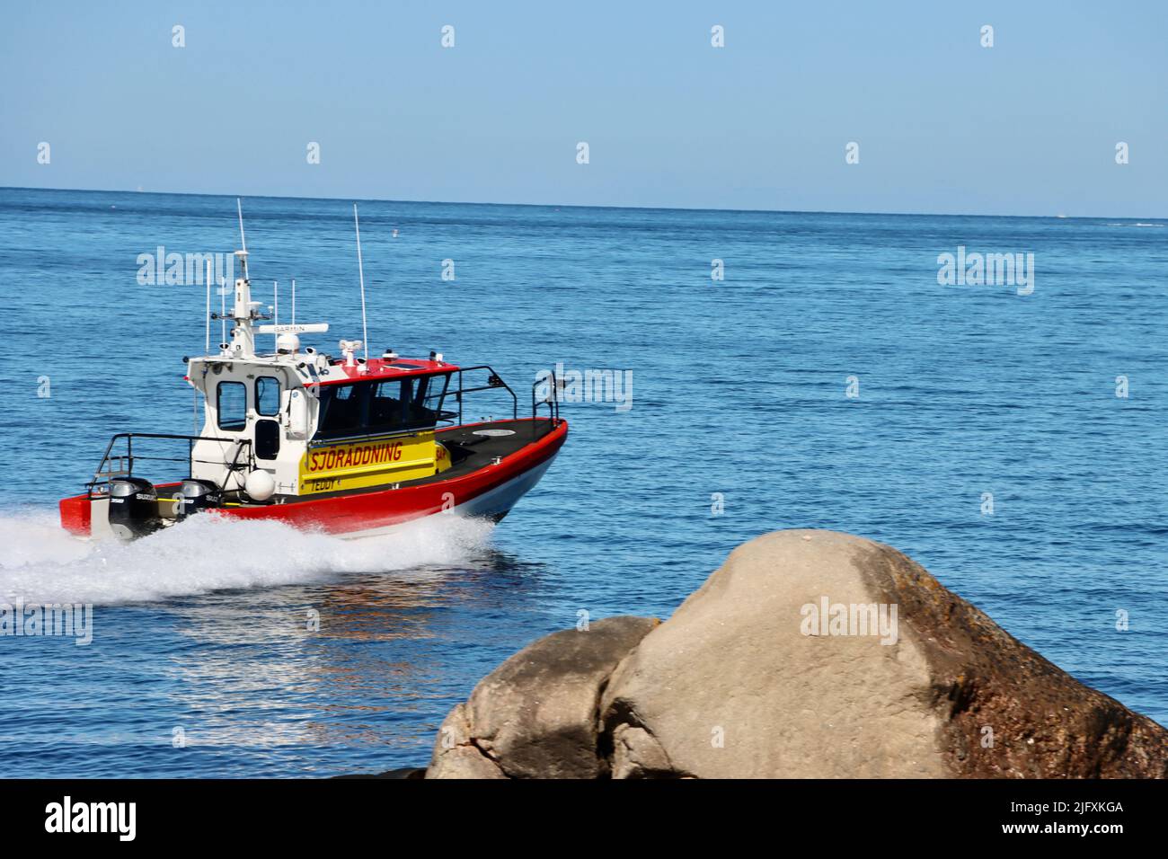 Nave di salvataggio svedese in mare passando per la costa rocciosa dell'arcipelago di Fjällbacka nel giugno 2022 Foto Stock