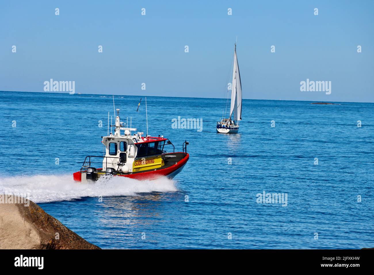 Nave di salvataggio svedese in mare passando per la costa rocciosa dell'arcipelago di Fjällbacka nel giugno 2022 Foto Stock