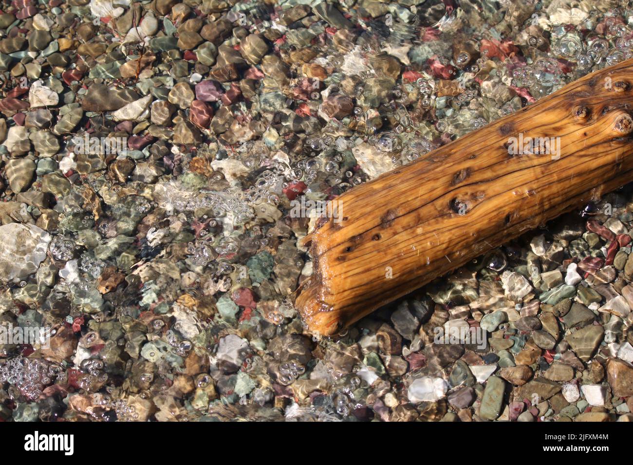 Colorato rosso e oro cintura serie sedimentario precambriano argillite e sassi calcarei in acque incontaminate lago St Mary, Glacier National Park, MT, USA Foto Stock