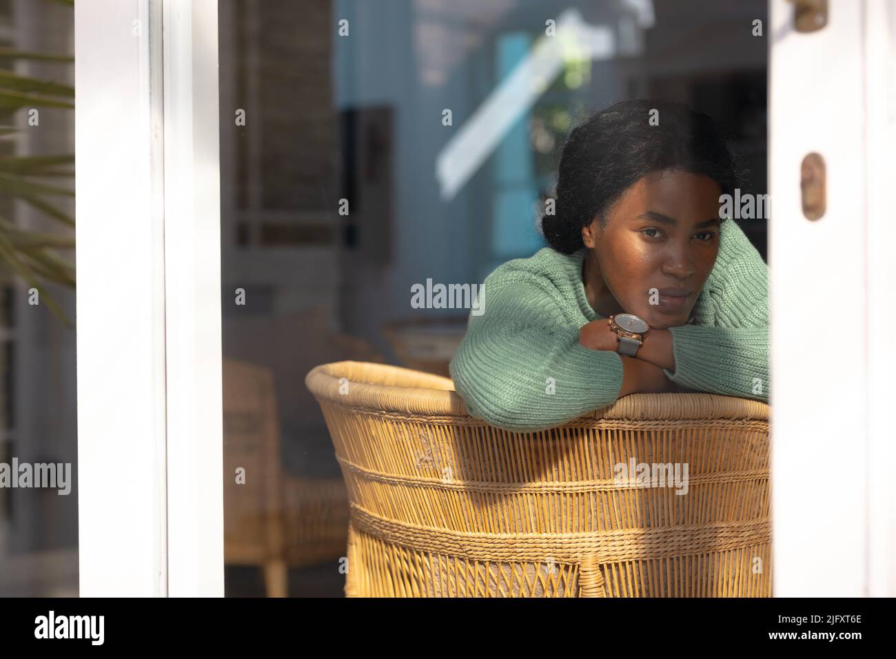 Giovane donna afroamericana pensata a casa vista attraverso la finestra, spazio copia Foto Stock