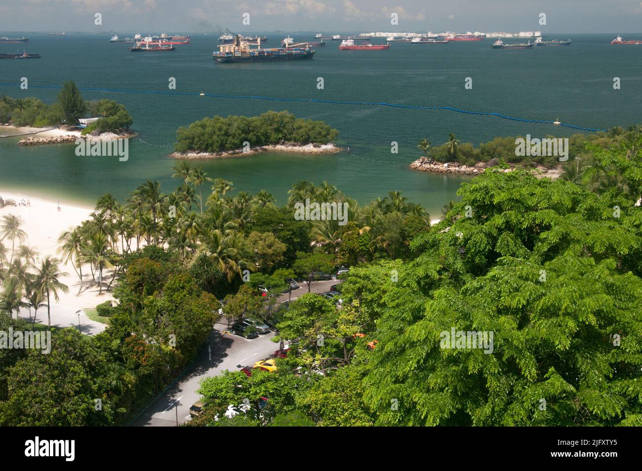 Spiagge dell'Isola di Sentosa da sopra Siloso Beach, Singapore, accanto ad un trafficato canale di navigazione Foto Stock