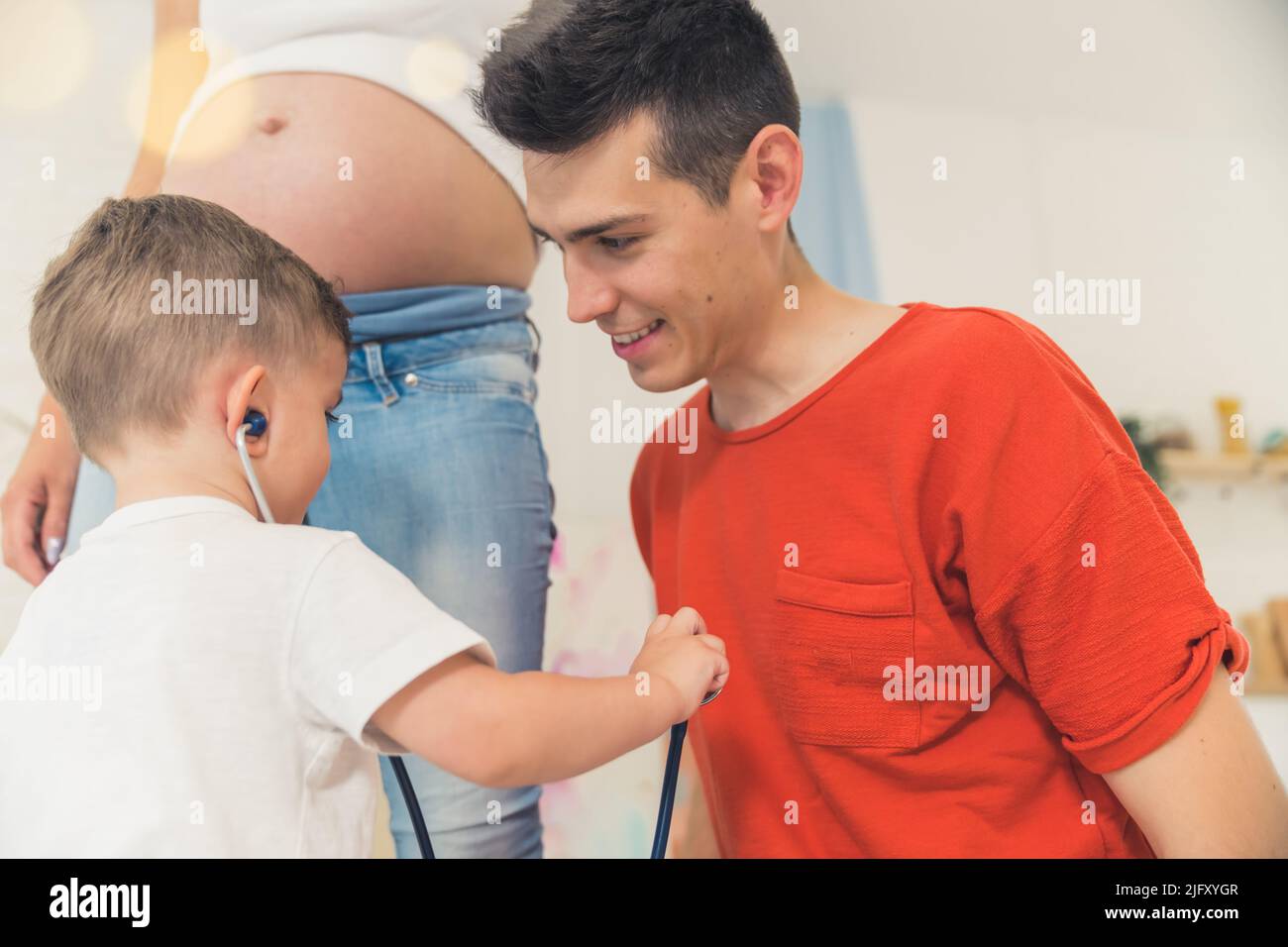 ragazzino che usa uno stetoscopio per ascoltare il battito del papà. Foto di alta qualità Foto Stock