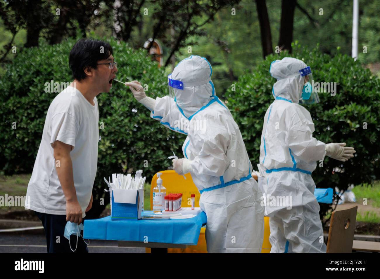 Un operatore medico prende un campione di tampone in una stazione di analisi degli acidi nucleici, a seguito di un focolaio di coronavirus (COVID-19), a Pechino, Cina, 6 luglio 2022. REUTERS/Thomas Peter Foto Stock