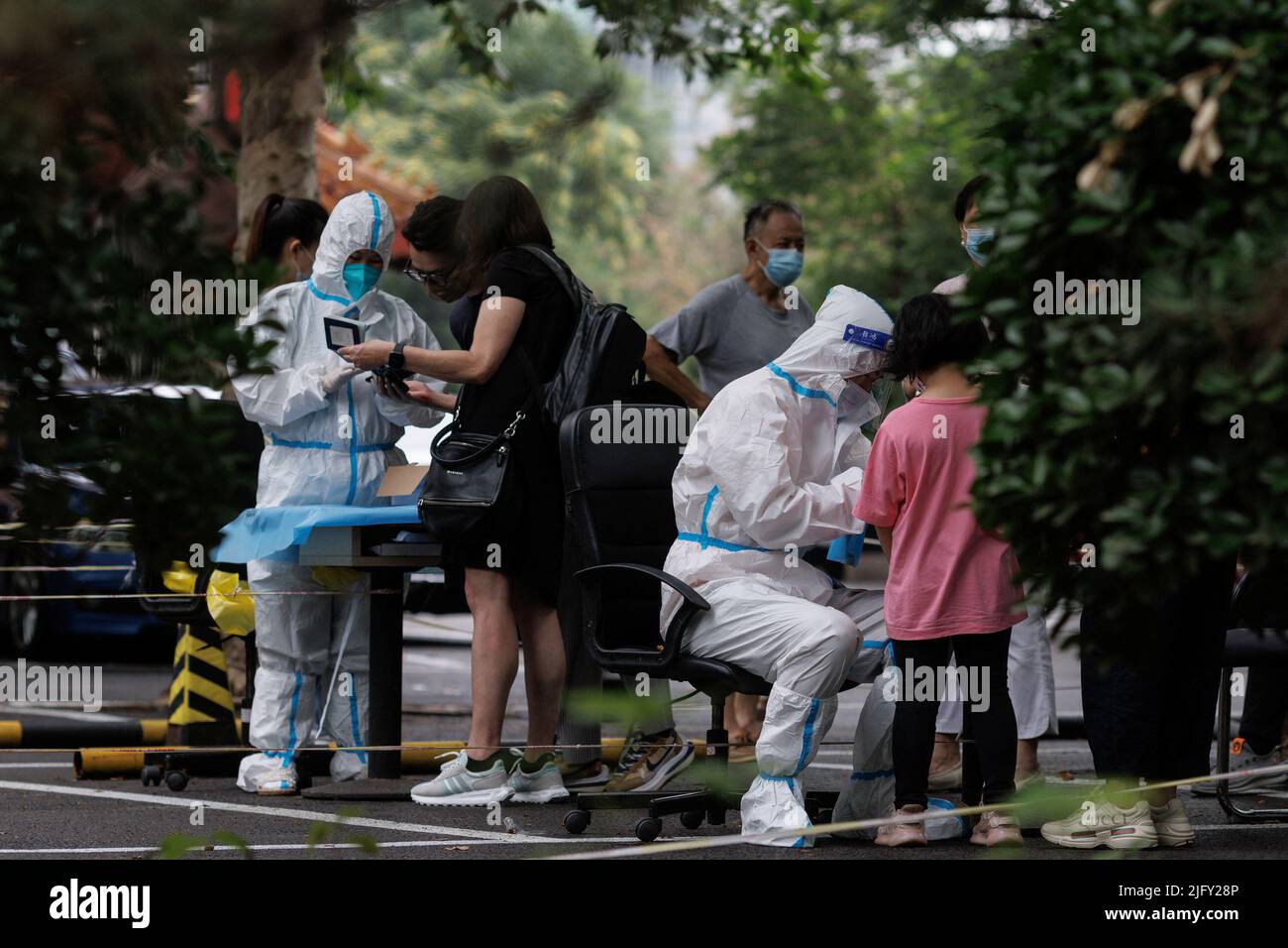 Gli operatori sanitari registrano le persone in una stazione di analisi degli acidi nucleici, a seguito di un focolaio di coronavirus (COVID-19), a Pechino, Cina, 6 luglio 2022. REUTERS/Thomas Peter Foto Stock