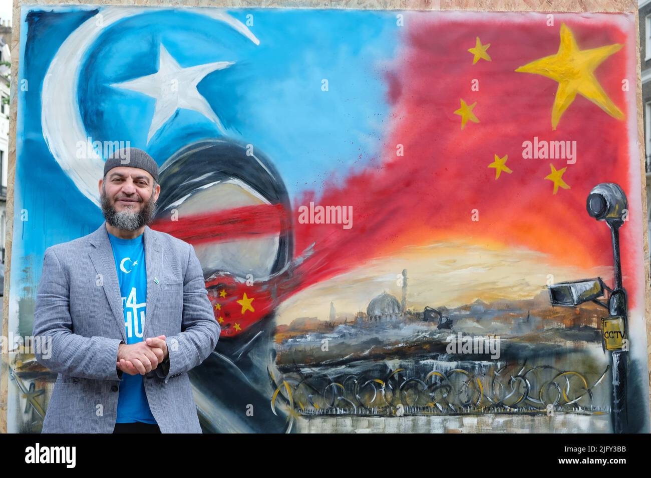 Londra, Regno Unito. 5th luglio 2022. Shams, un artista con sede a Londra, crea un potente dipinto di protesta dal vivo di fronte all'ambasciata cinese per sensibilizzare l'opinione pubblica sulla situazione di Uyghur. Quest'anno ricorre il 13th° anniversario delle letali rivolte razziali di Urumqi, nella regione autonoma di Xinjiang (Turkestan orientale) che, dopo essere stata dominata dalla forza militare, ha avuto conseguenze durature grazie all'introduzione di uno Stato di sorveglianza, di campi di rieducazione e di lavoro, di sterilizzazione e di altre violazioni dei diritti umani, che equivalgono al genocidio, Anche se negata dalla Cina. Credit: Undicesima ora Fotografia/Alamy Live News Foto Stock