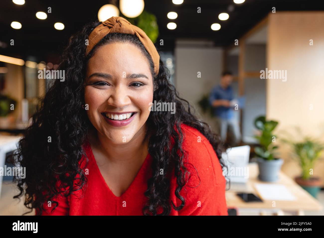 Ritratto di sorridente metà adulta biraciale creativa donna d'affari in ufficio Foto Stock