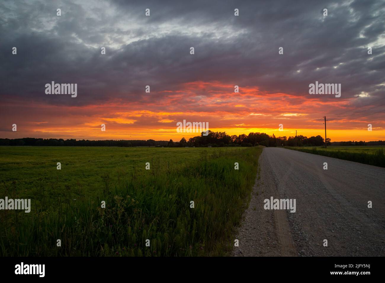 Paesaggio rurale paesaggistico con strada sterrata rurale rotto al tramonto. Foto Stock