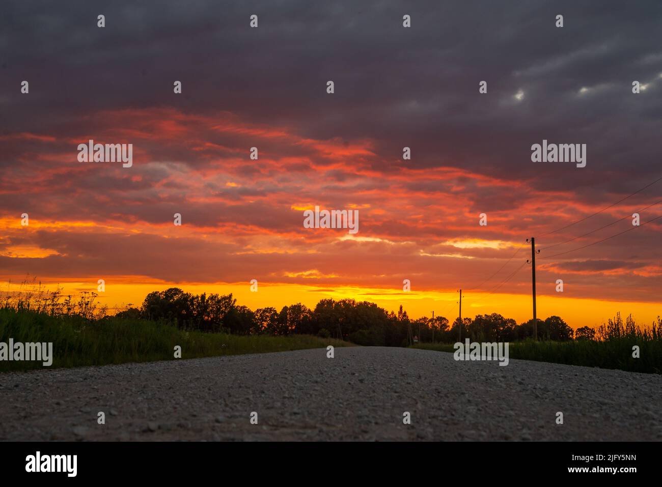 Paesaggio rurale paesaggistico con strada sterrata rurale rotto al tramonto. Foto Stock