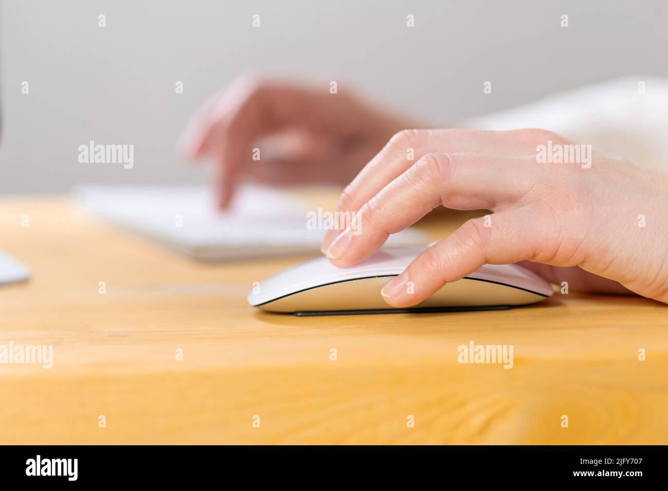 Primo piano delle giovani donne mani premendo i tasti della tastiera e usando un mouse. Lavoro da casa. ufficio. Shopping Foto Stock