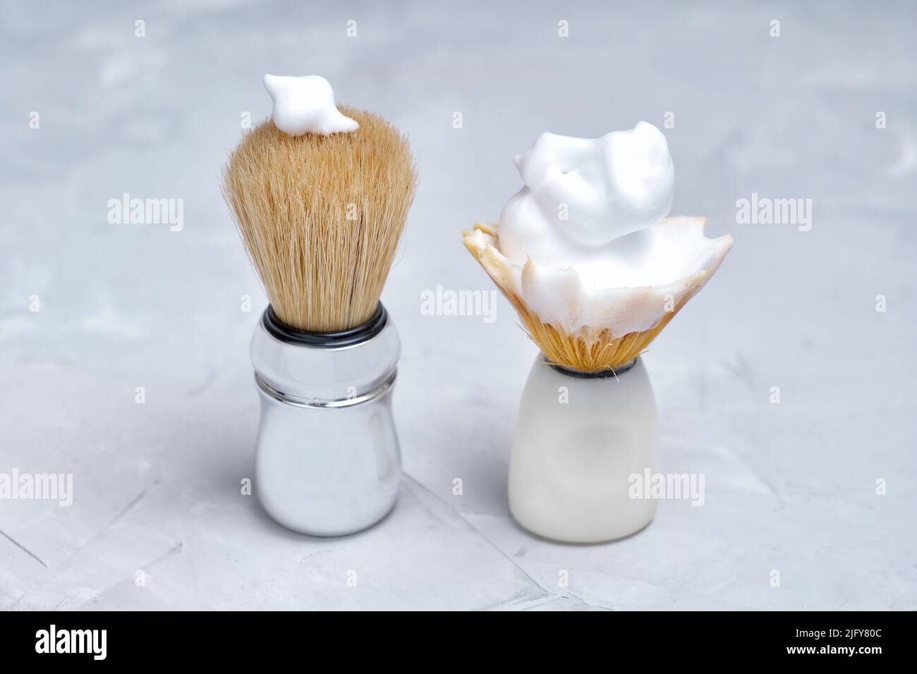 Confronto tra una spazzola di rasatura nuova e una usurata. Risparmio attraverso la spesa. Foto Stock