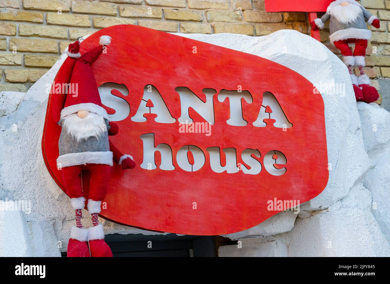 Cartello con il logo Santa House all'ingresso della casa. Natale e Capodanno. Decorazione. Lettere e frasi su asse rosso di legno Foto Stock