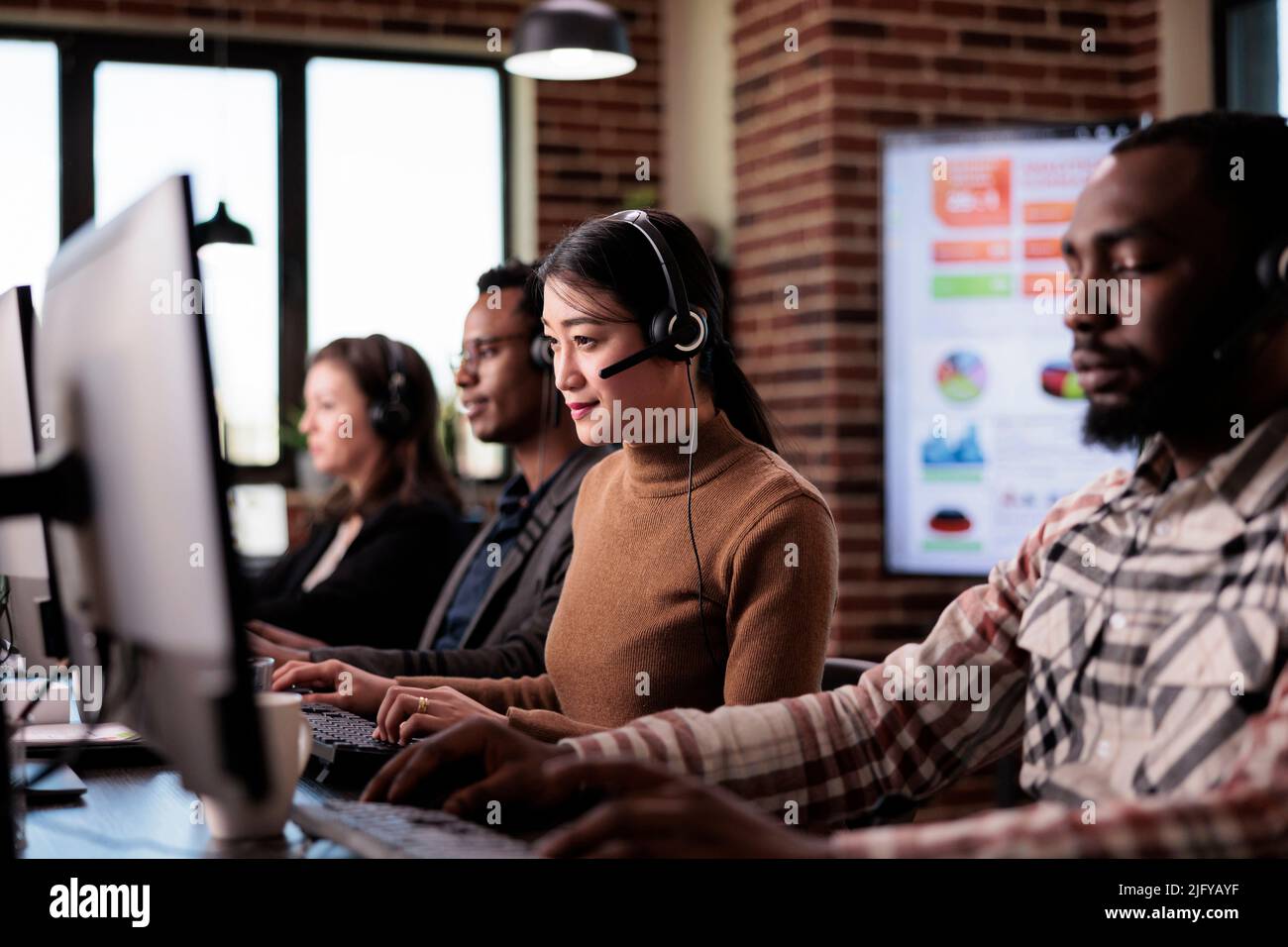 Donna asiatica che lavora come consulente di vendita al servizio di call center, aiutando i clienti al supporto di customer care. Assistente per le telecomunicazioni con helpline di telemarketing alla reception. Foto Stock