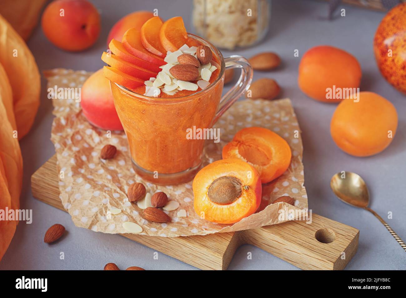 Purea di albicocche fresche o frullato con mandorla su sfondo rustico chiaro. Concetto di cibo sano Foto Stock