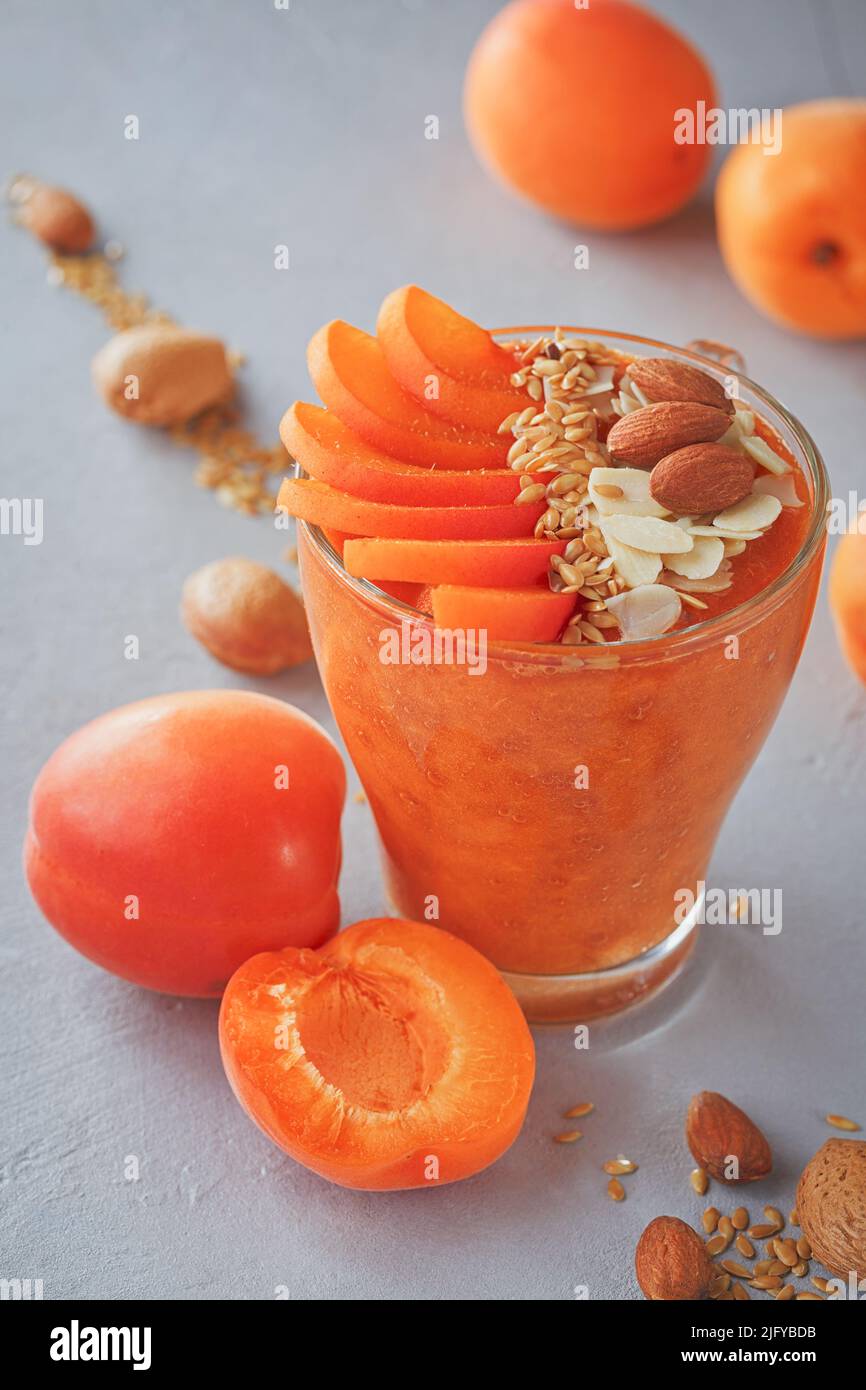 Purea di albicocche fresche o frullato con mandorla su sfondo rustico chiaro. Concetto di cibo sano Foto Stock