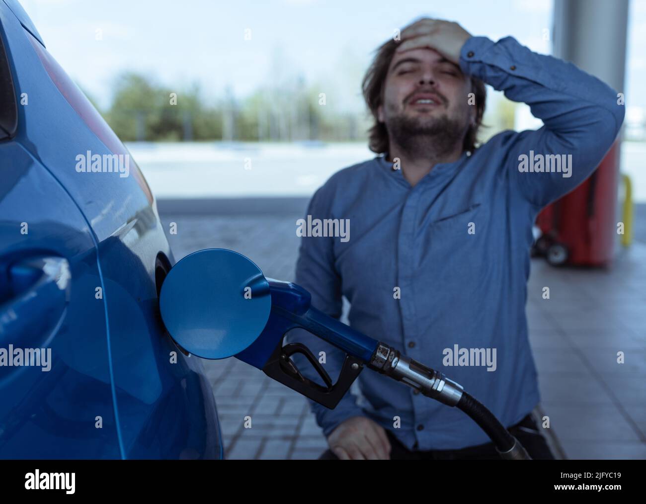 rifornimento di una macchina con benzina in una stazione di servizio. Aumento dei prezzi del carburante. Crisi e mancanza di benzina. Un uomo urla con rabbia vicino alla stazione di servizio Foto Stock