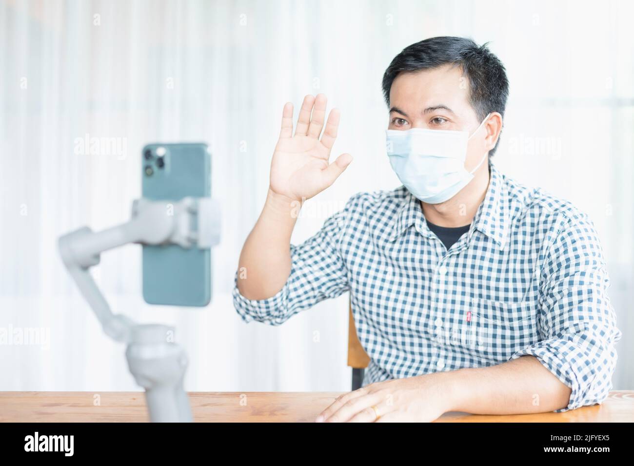 Uomo asiatico indossare maschera preventiva e lavorare da casa in situazione di malattia di Corona Virus (COVID-19). Lavora da casa e concetto sano Foto Stock