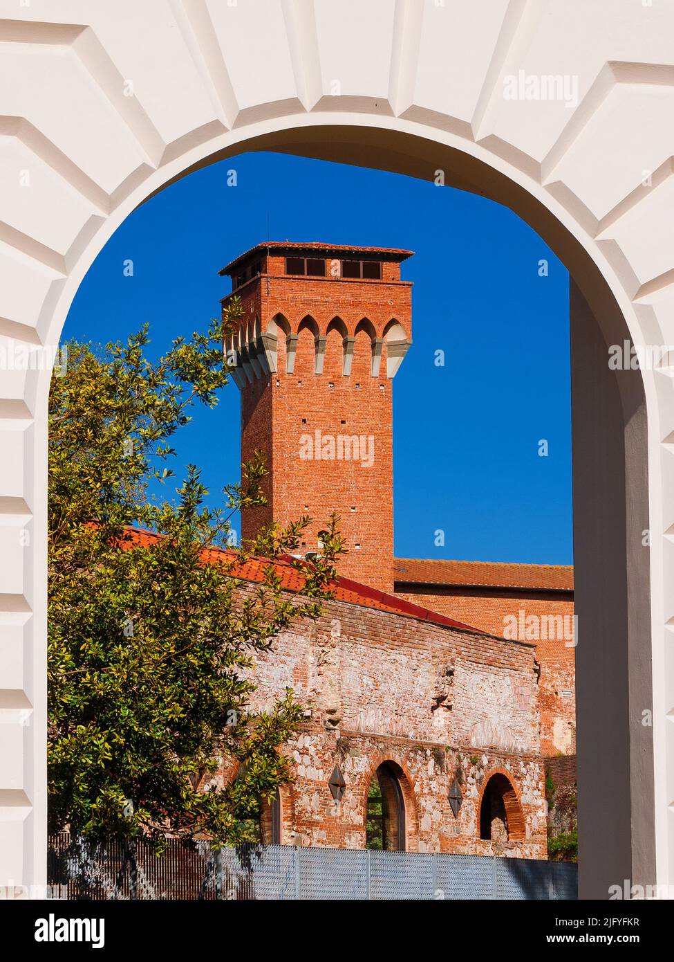 Torre medievale vista attraverso l'antica porta delle mura di Pisa Foto Stock
