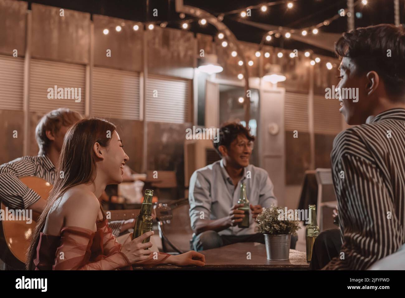 Gruppo di giovani amici che si godono il pasto e celebrare l'amicizia in pub e ristorante Foto Stock
