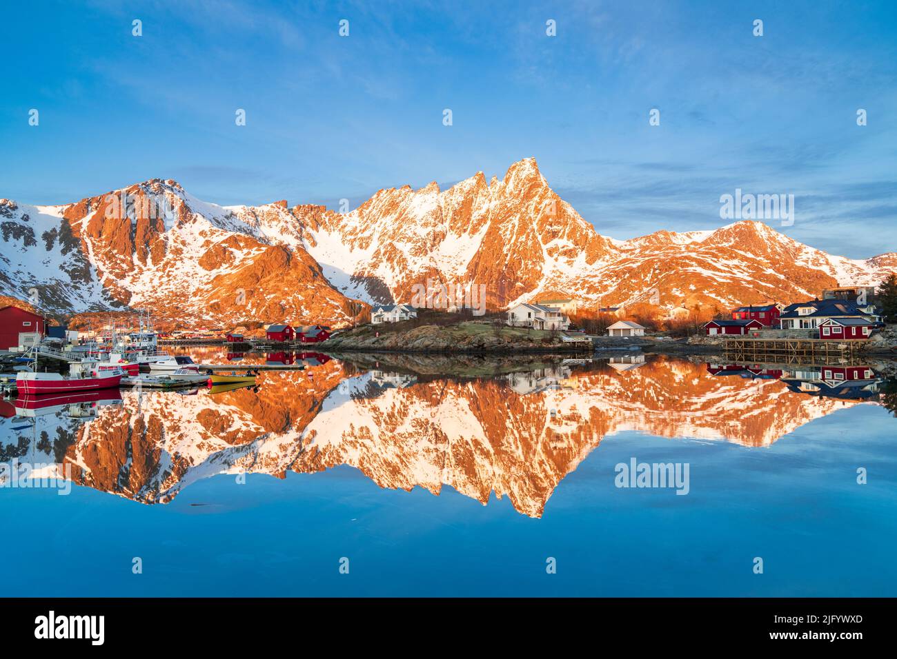 Montagne maestose e villaggio di pescatori che si riflettono nel mare freddo, Ballstad, Vestvagoy, Isole Lofoten, Norvegia, Scandinavia, Europa Foto Stock
