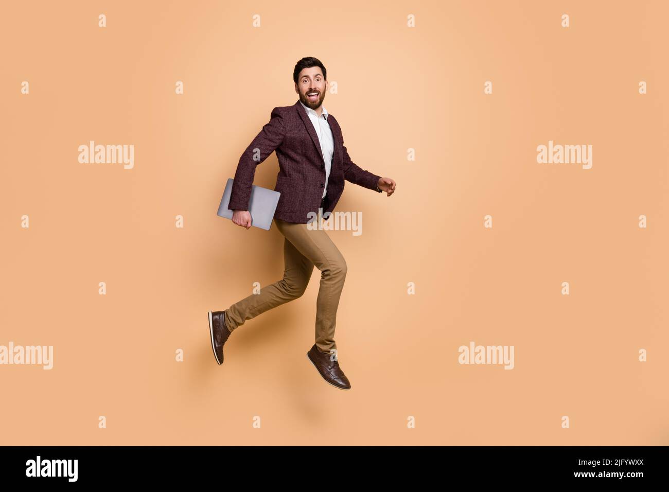 Immagine a grandezza naturale di un giovane uomo d'affari che lavora in un'azienda del centro città vanno a lavorare isolato su sfondo di colore beige Foto Stock