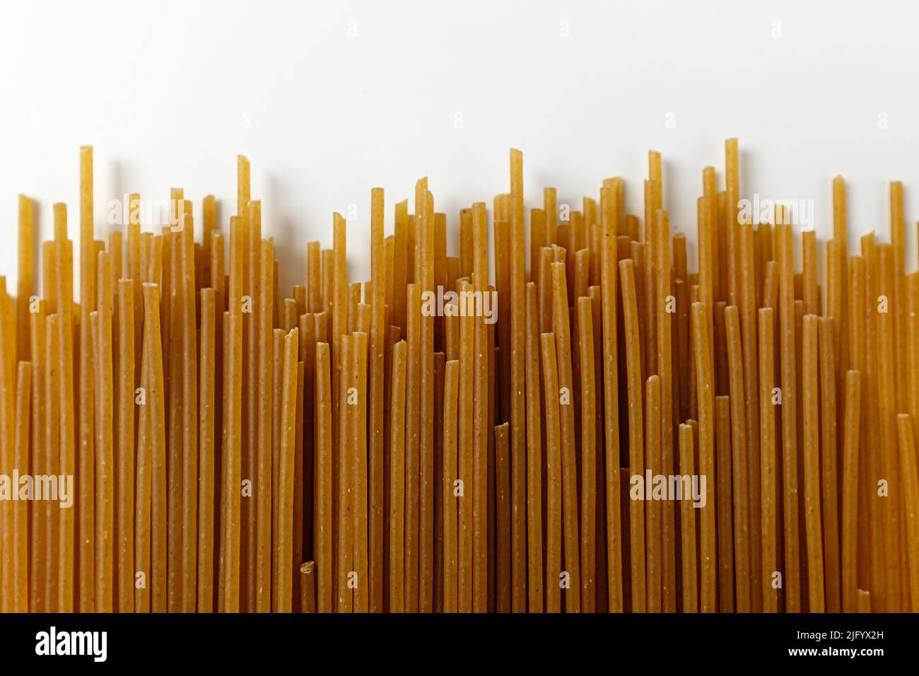 Spaghetti di grano integrale su sfondo bianco Foto Stock
