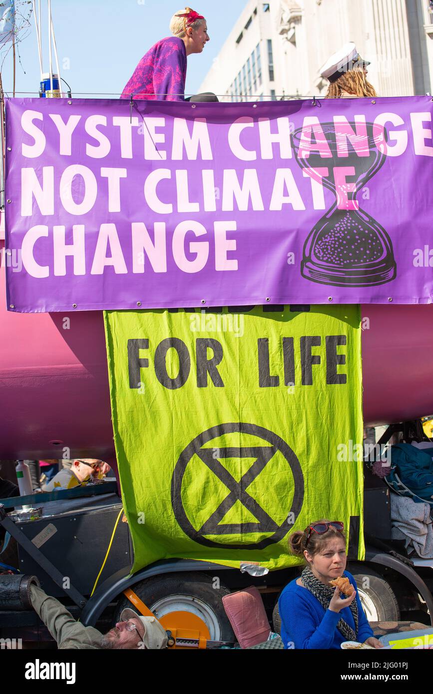 I manifestanti sul cambiamento climatico con i loro segnali alla manifestazione della ribellione dell'estinzione, Londra, per protestare contro la rottura del clima mondiale e il collasso ecologico. Foto Stock