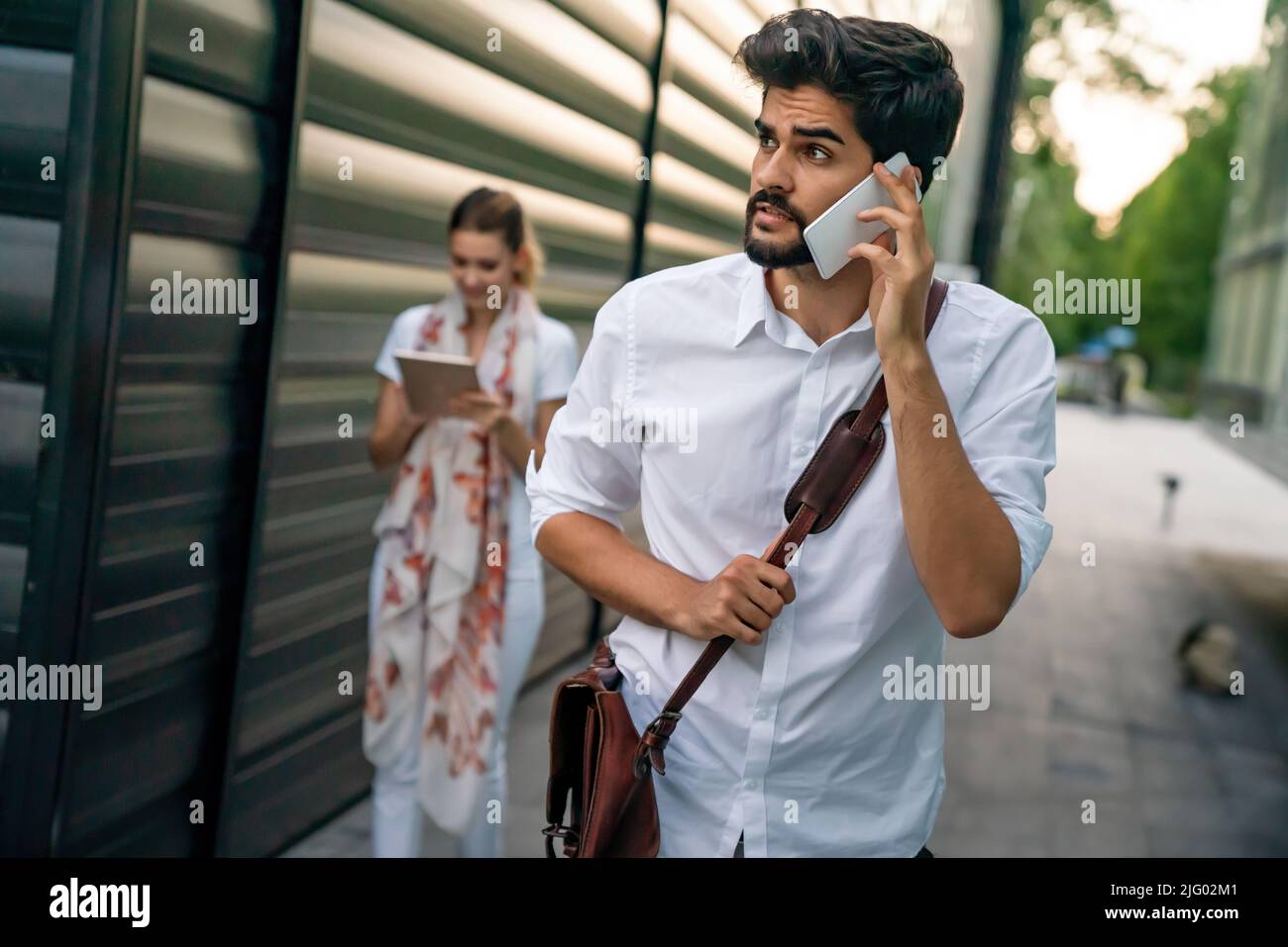 Felici le persone che lavorano all'aperto con i dispositivi digitali. Tecnologia aziendale smartphone, tablet Foto Stock