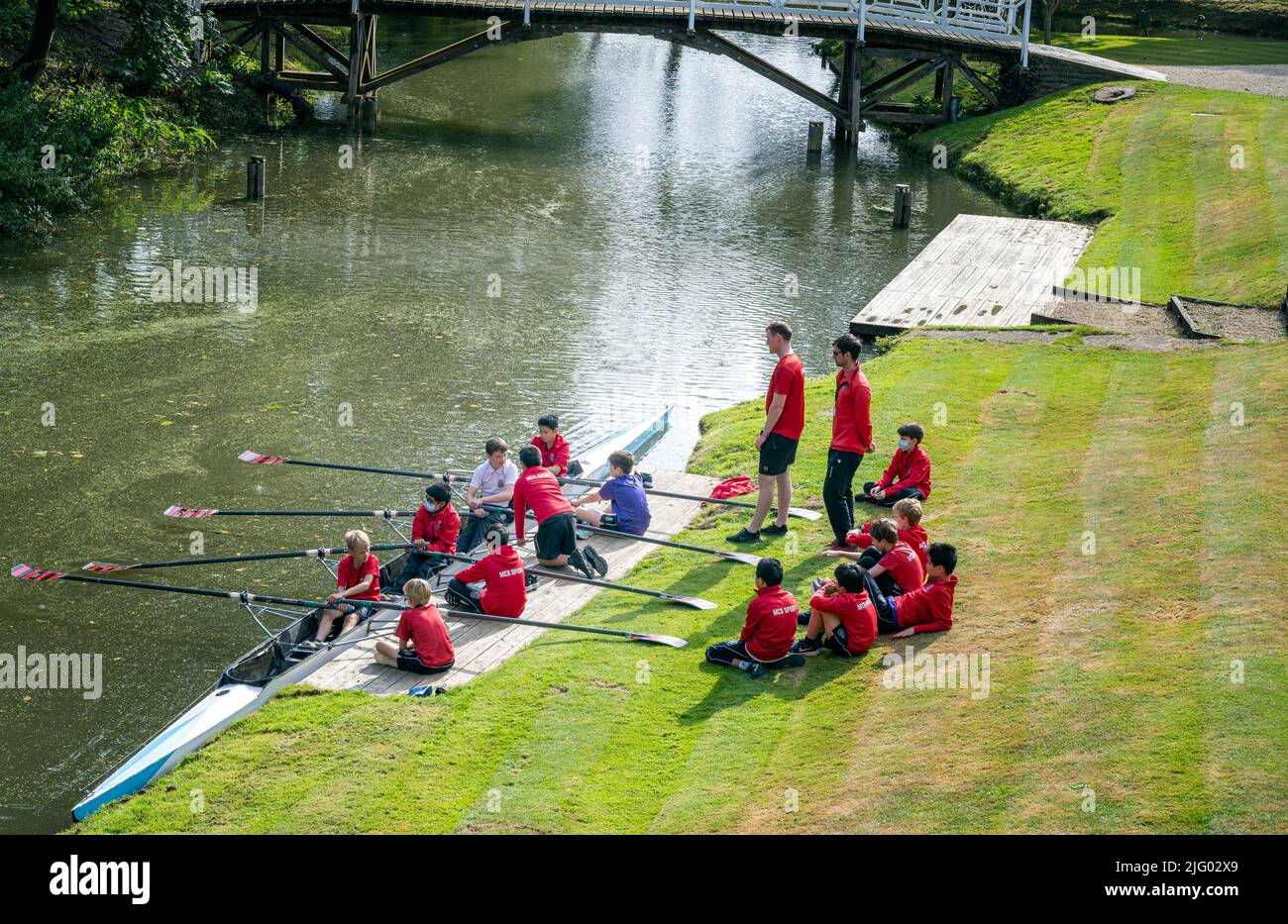Giovani ragazzi maschi di insegnanti della Magdalen College School Oxford che hanno canottaggio scolpendo le lezioni di barca scull sulle rive del fiume Cherwell Foto Stock