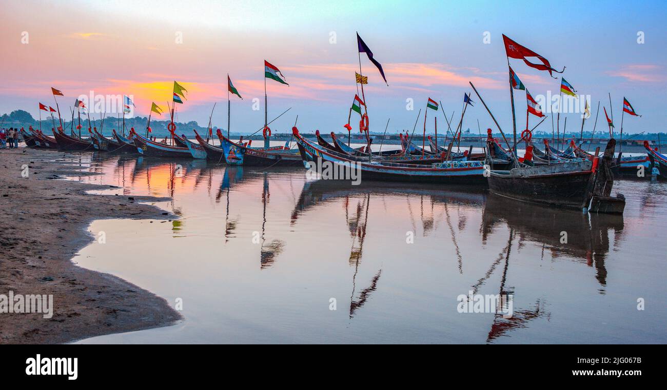 Chandod: 7,Novembre,2009; riflessione di tradizionali barche di legno ancorate nel fiume Narmada contro Sunrise, Chandod, Gujarat, India Foto Stock