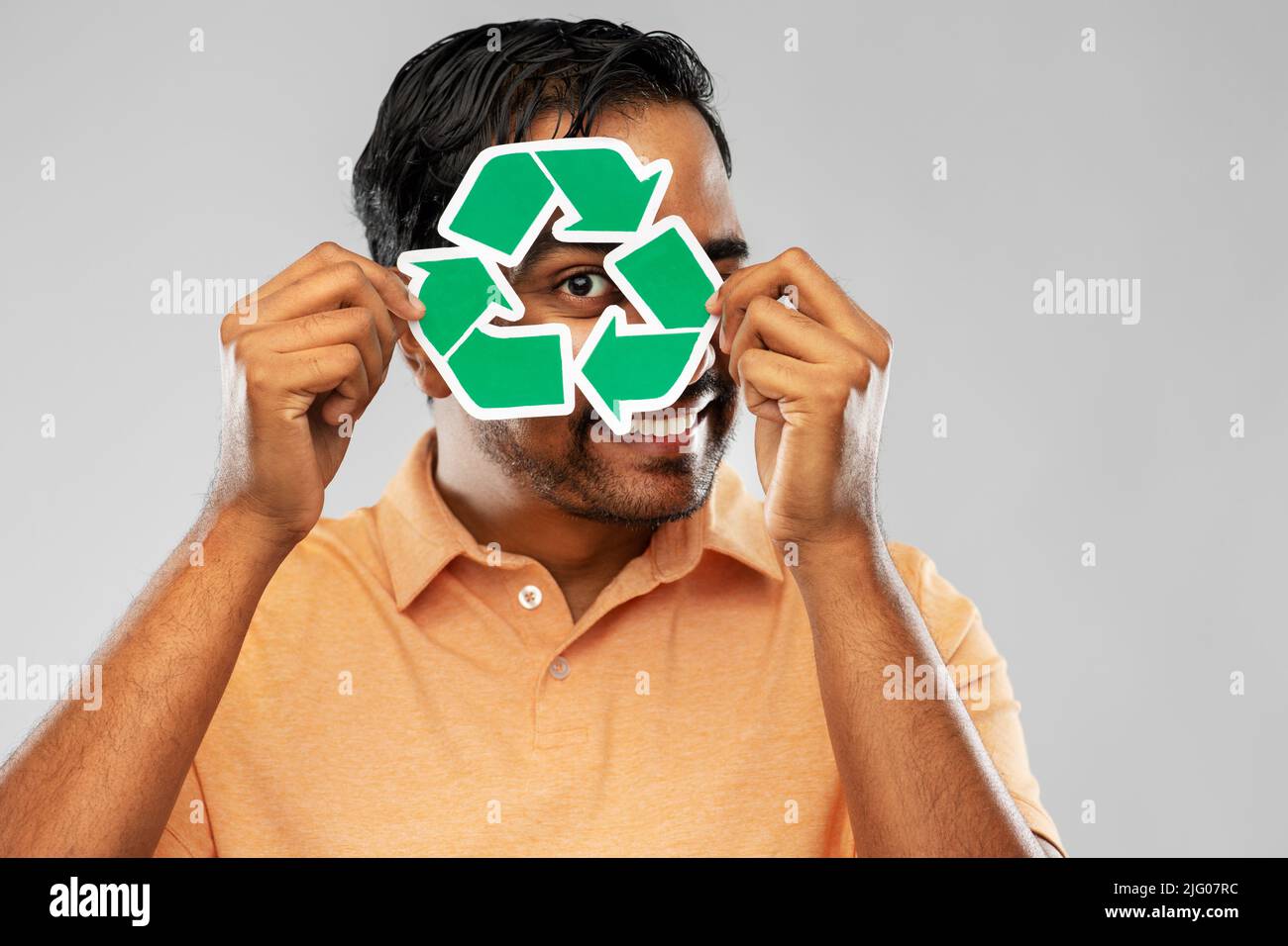 uomo indiano sorridente che tiene segno verde di riciclaggio Foto Stock