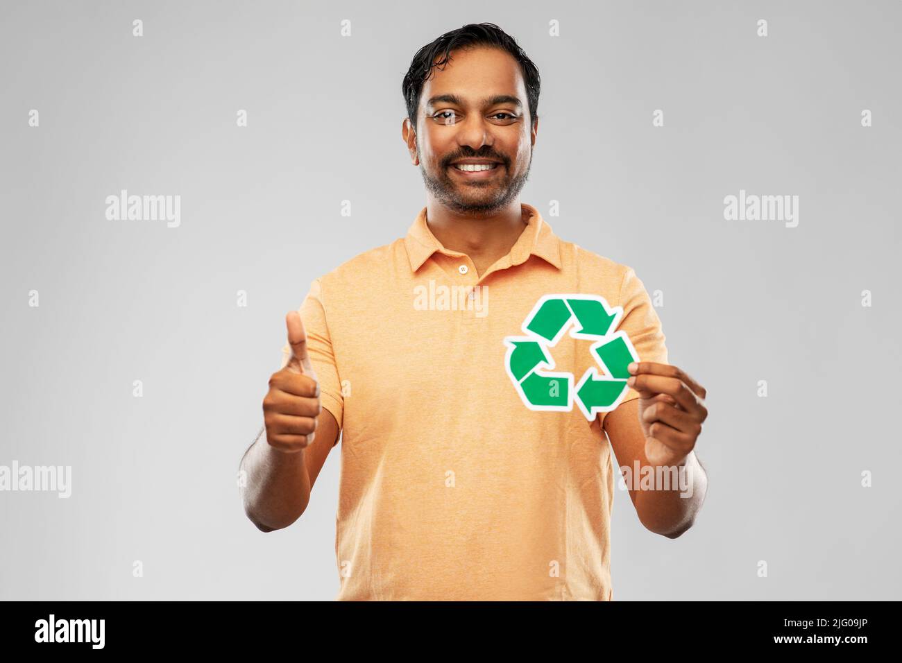 uomo indiano sorridente che tiene segno verde di riciclaggio Foto Stock