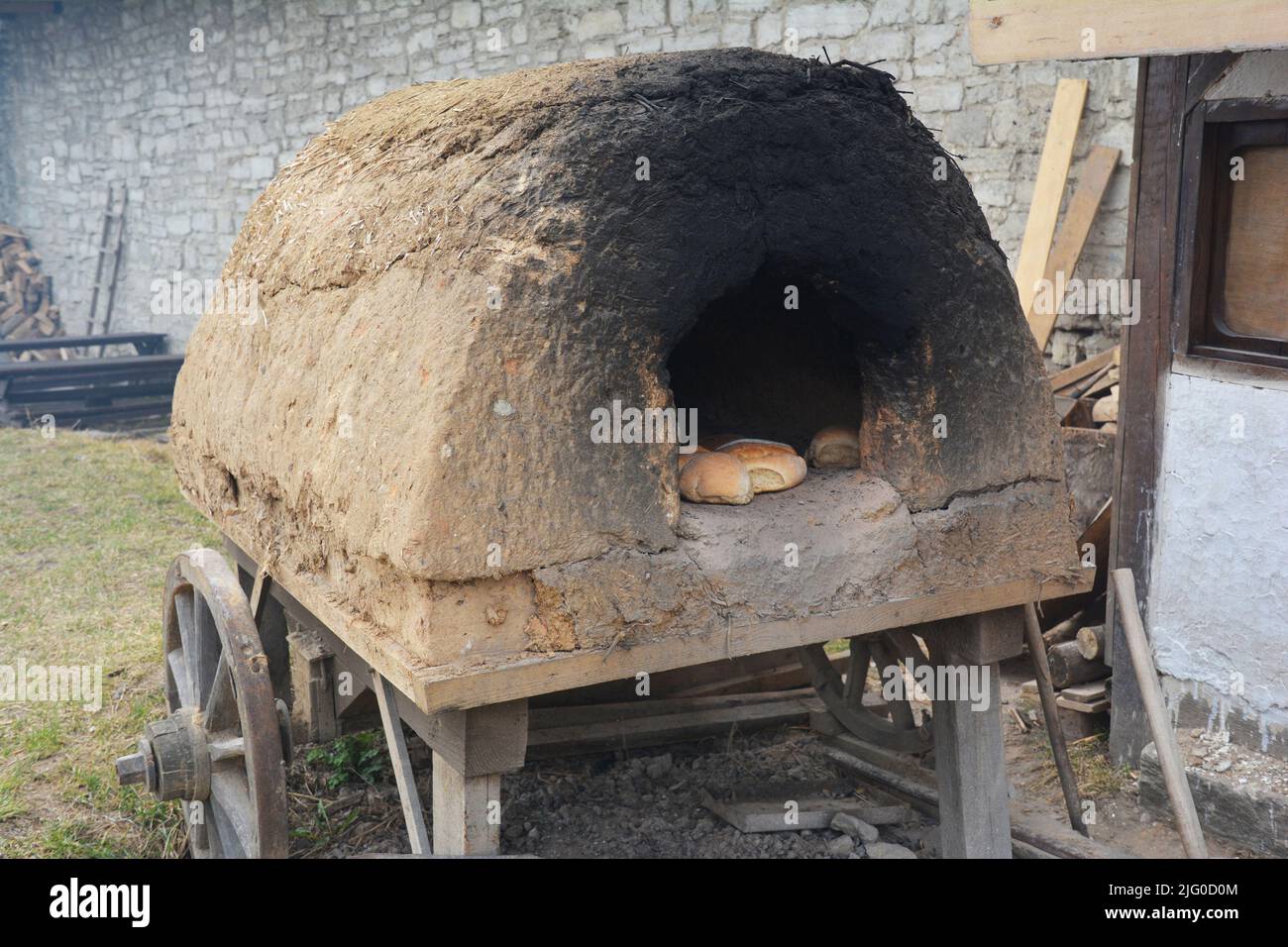 Un carro storico ricostruito in legno, un carro in legno con un forno di argilla sulla parte superiore con pane cotto al forno. Cottura del pane nei vecchi giorni. Foto Stock