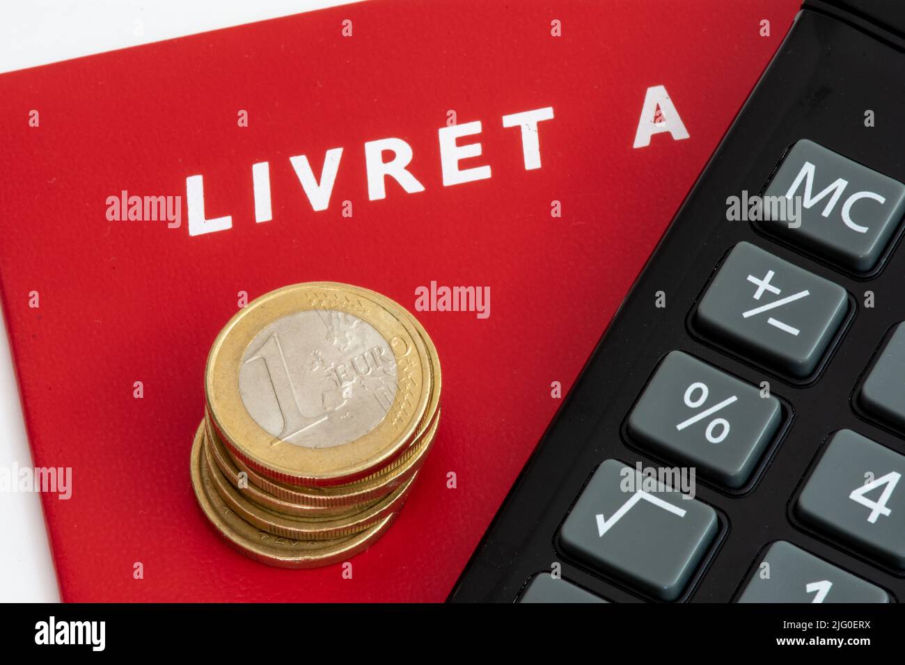 Francia: Livret un libretto con una pila di monete in euro e un calcolatore. Il Livret A è un conto di risparmio francese regolamentato Foto Stock
