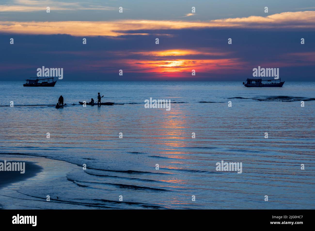 La gente si affaccia su un tramonto tropicale e colorato sul mare Foto Stock