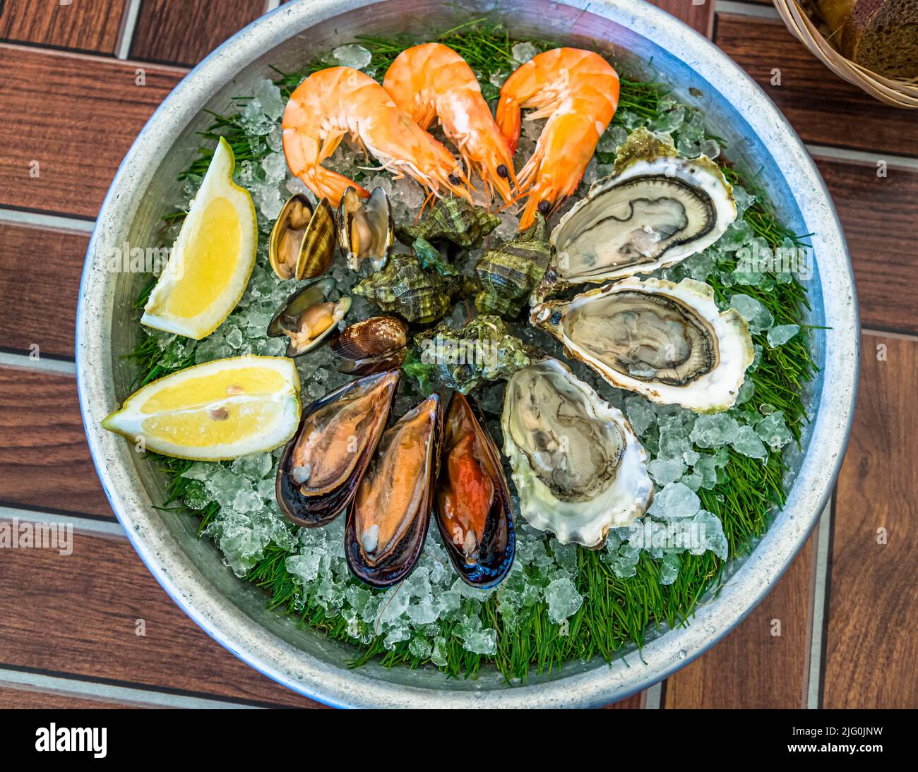 Un piatto di ostriche crude, cozze, gamberetti e probabilmente capesante su ghiaccio e fronde di finocchio si trova in un ristorante sull'Étang de Thau vicino a Bouzigues, Hérault, Francia. Si dice che le ostriche della laguna abbiano un sapore simile alla mandorla, grazie all'acqua ricca di minerali alimentata dal Canal du Midi. Foto Stock