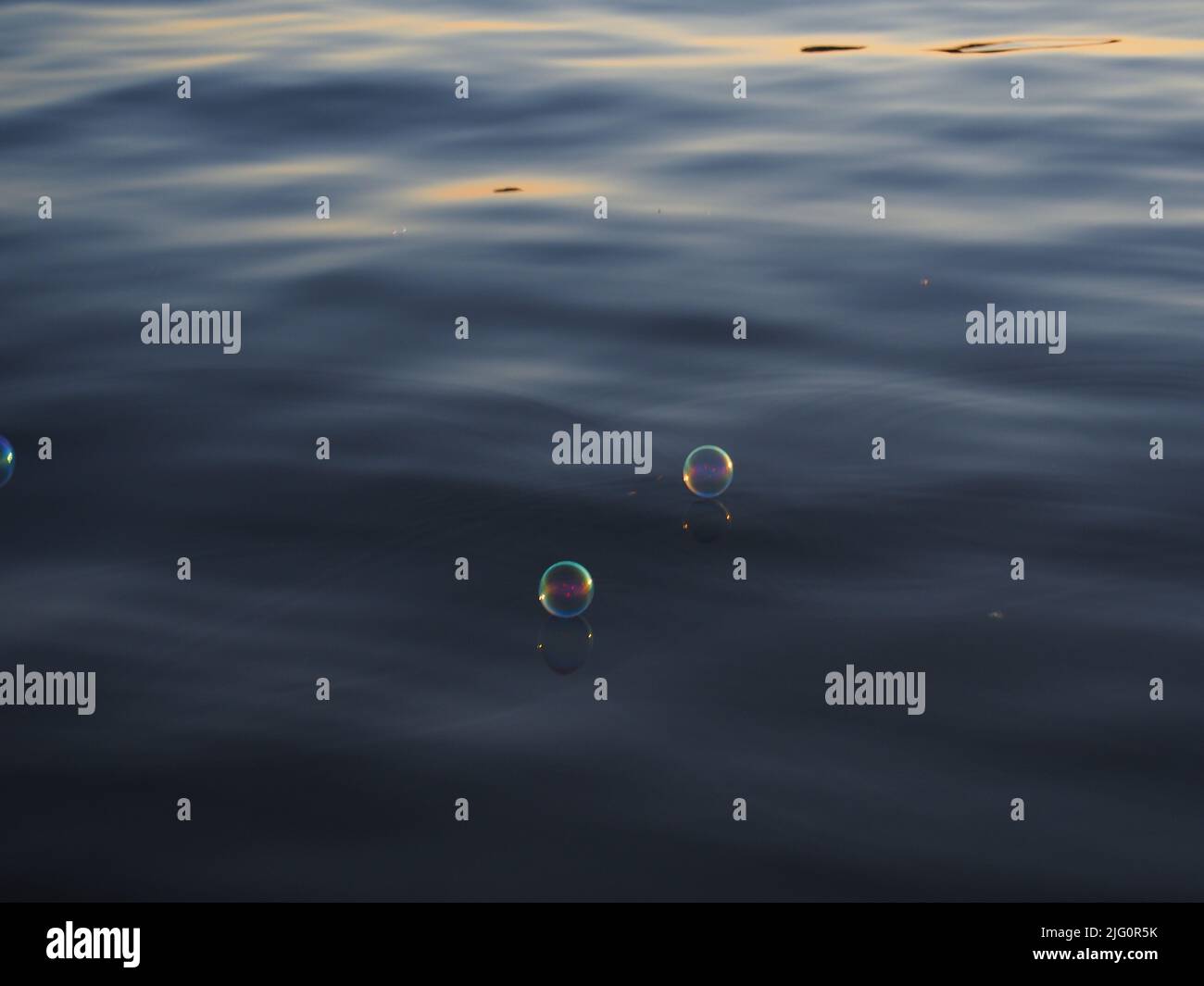 Bolle d'aria che galleggiano sull'acqua Foto Stock