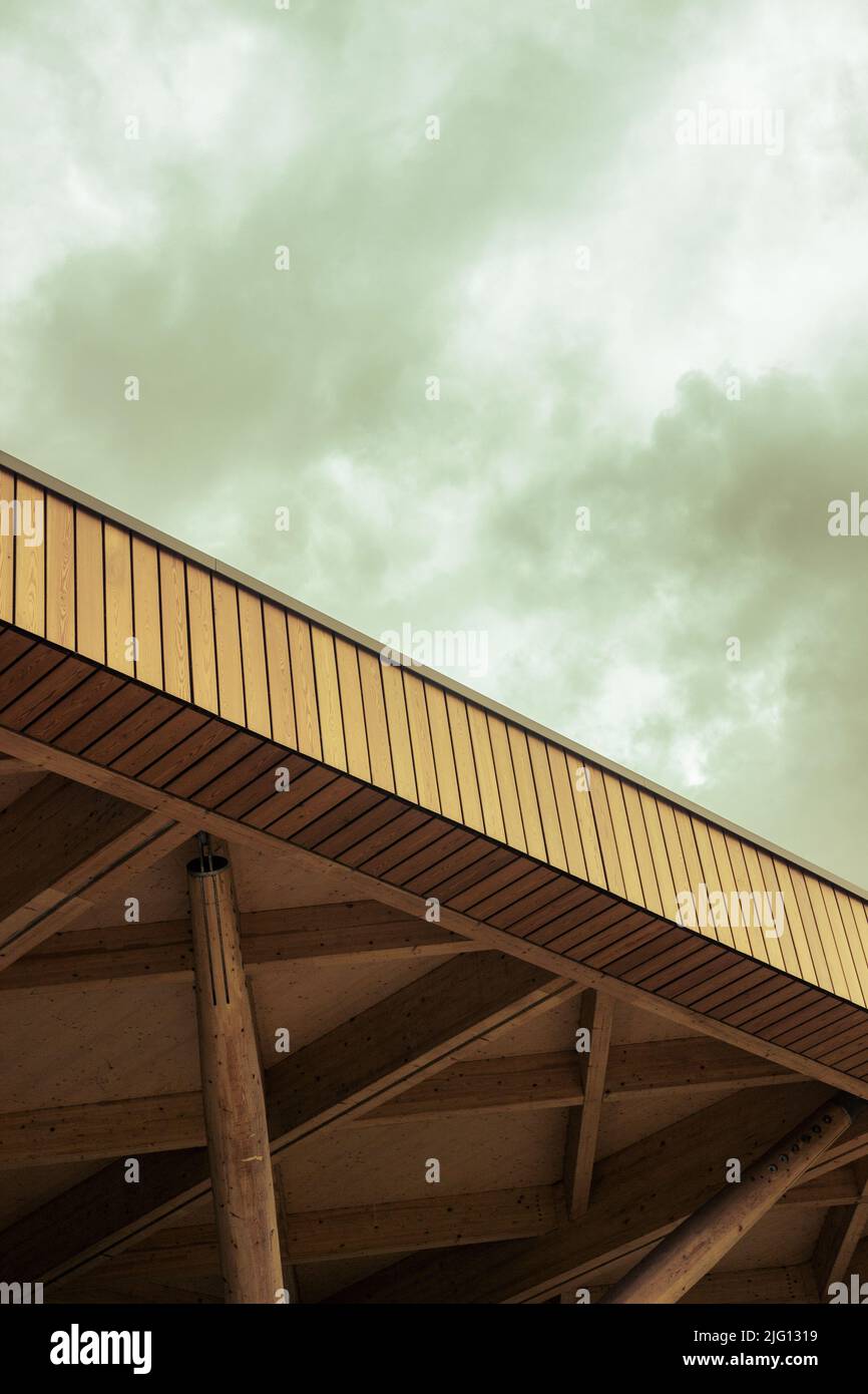 Una sezione di tetto di legno su un edificio sotto un cielo moody. Foto Stock