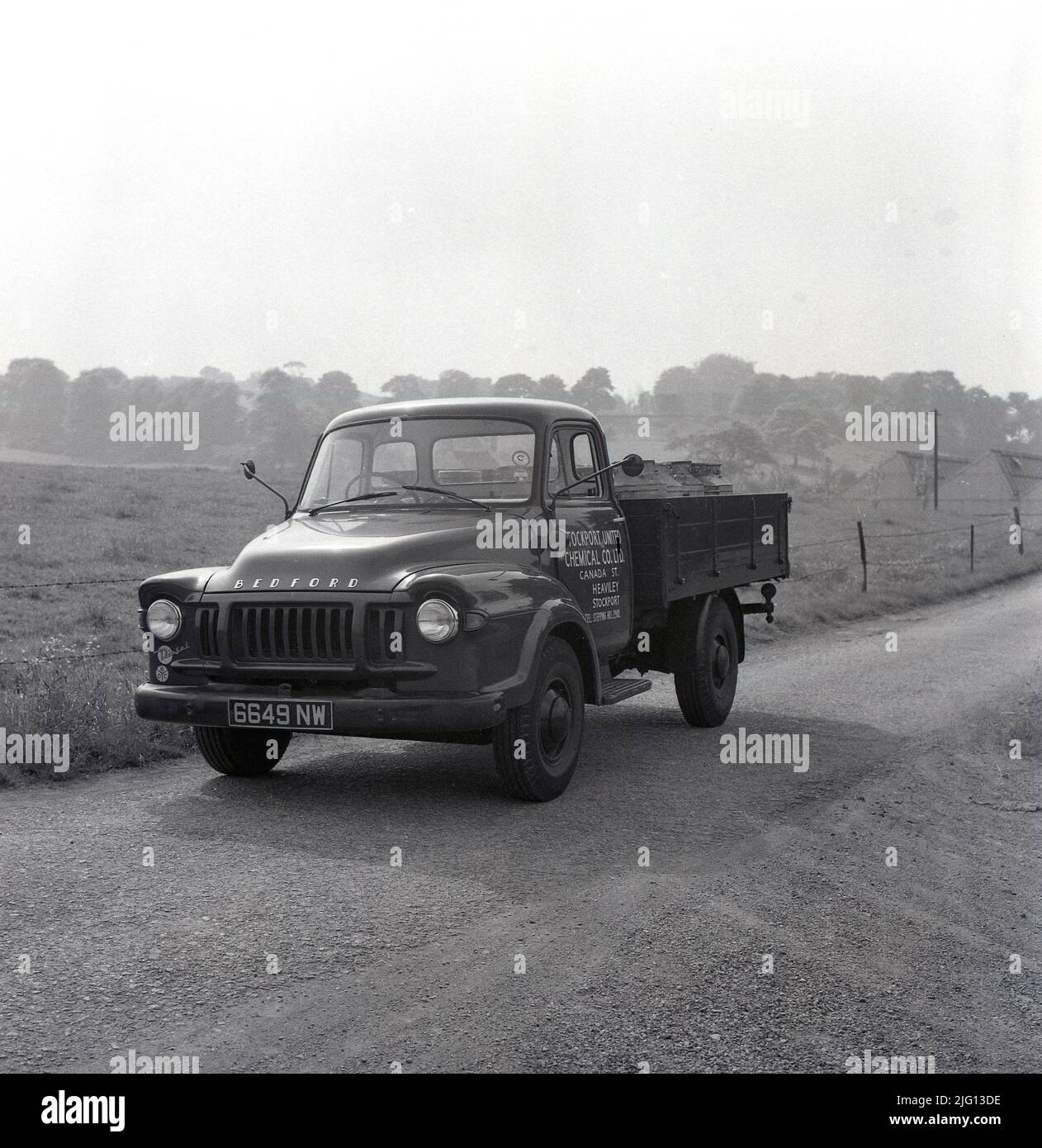 1959, storico, un camion Bedford TJ della Stockport United Chemical Co Ltd, su una strada di ingresso stretta, ad un sito industriale rurale, Stockport, Manchester, Inghilterra, Regno Unito. Foto Stock