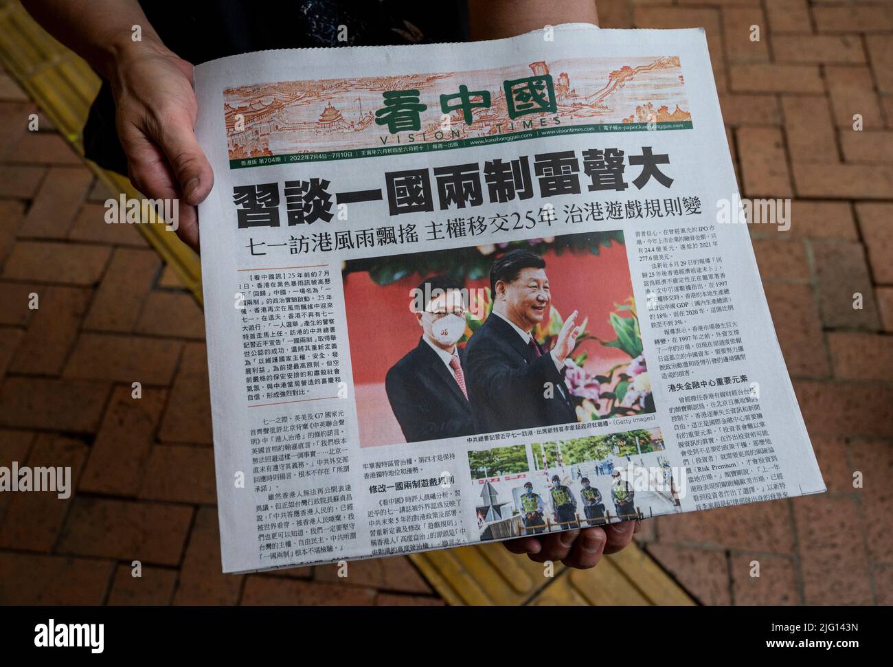 Hong Kong, Cina. 06th luglio 2022. Una donna distribuisce un giornale in lingua cinese Vision Times, con in prima copertina il capo esecutivo di Hong Kong John Lee (L) e il presidente cinese Xi Jinping a Hong Kong. Credit: SOPA Images Limited/Alamy Live News Foto Stock