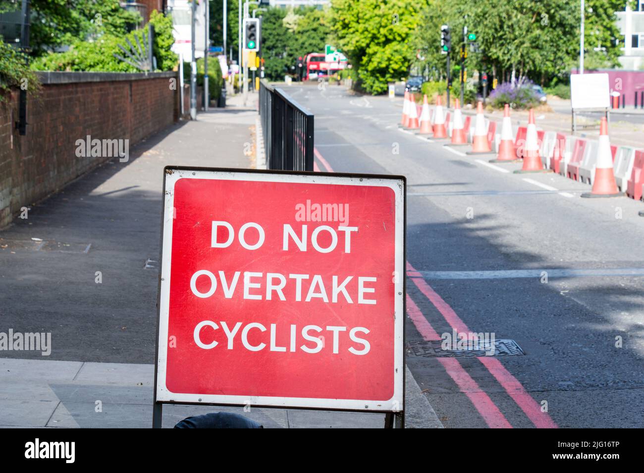 Non superare il cartello stradale dei ciclisti in una strada a corsia singola Foto Stock