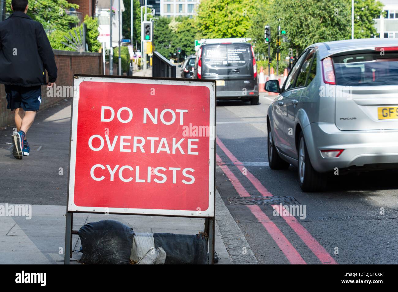 Non superare il cartello stradale dei ciclisti in una strada a corsia singola Foto Stock